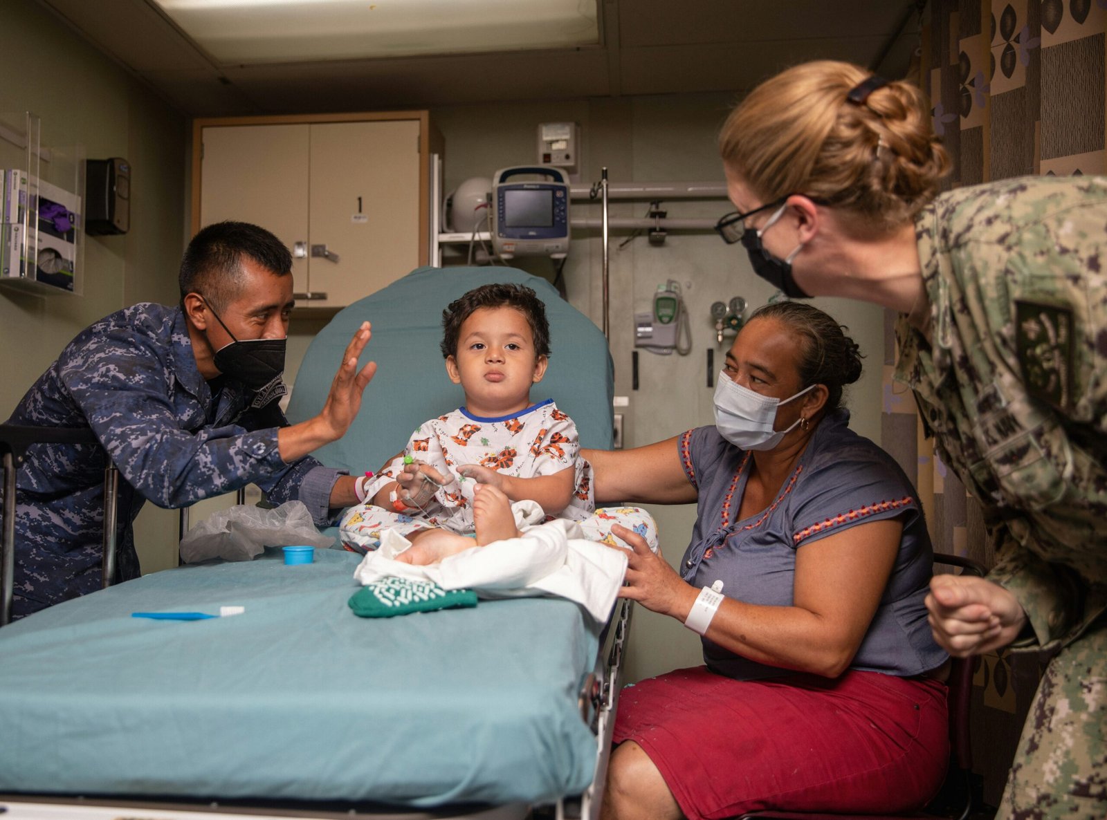 221030-N-VQ841-1092 PUERTO BARRIOS, Guatemala (Oct. 30, 2022) Capt. Kathryn Elliott, commanding officer of Medical Treatment Facility aboard hospital ship USNS Comfort (T-AH 20), right, checks on a young patient aboard Comfort, Oct. 30, 2022. Comfort is deployed to U.S. 4th Fleet in support of Continuing Promise 2022, a humanitarian assistance and goodwill mission conducting direct medical care, expeditionary veterinary care, and subject matter expert exchanges with five partner nations in the Caribbean, Central and South America. (U.S. Navy photo by Mass Communication Specialist 2nd Class Ethan J. Soto)