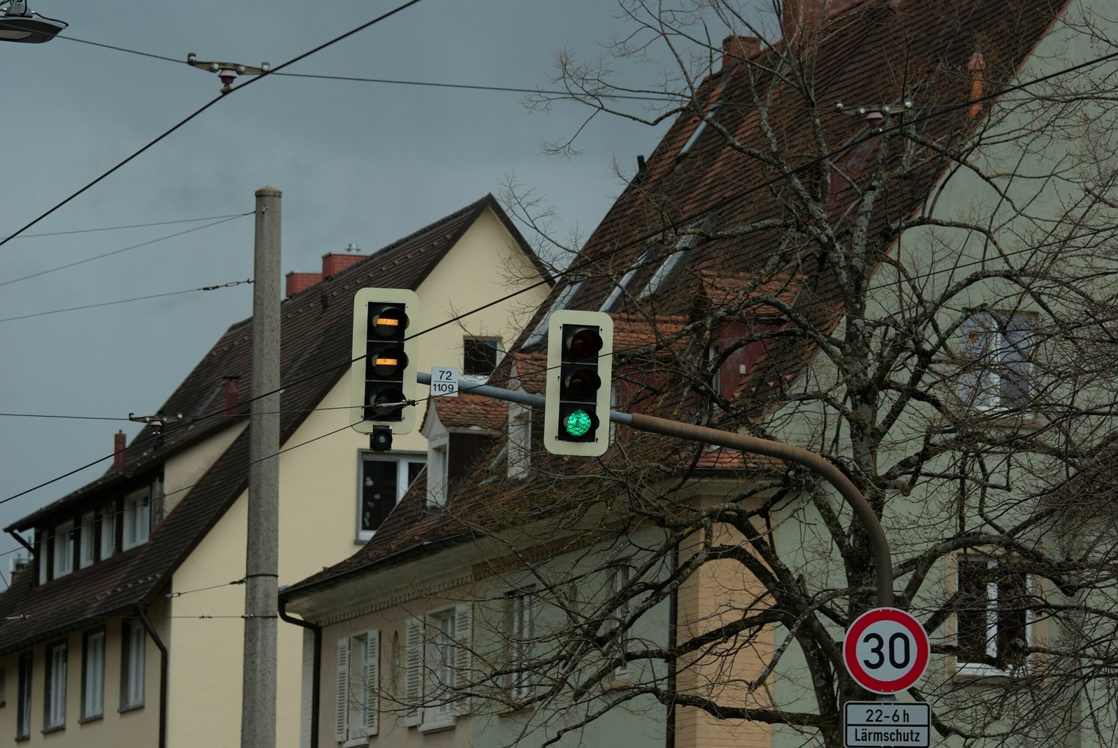 a green traffic light sitting next to a tall building