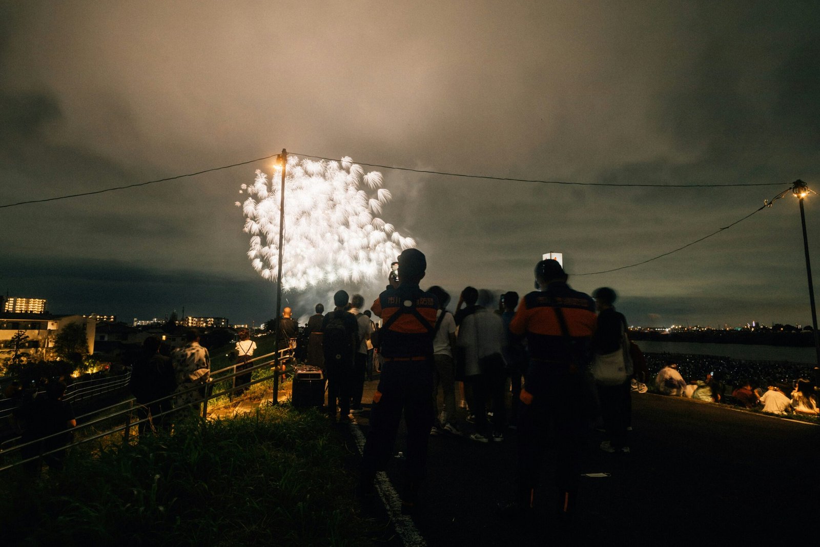 A group of people watching fireworks go off in the sky