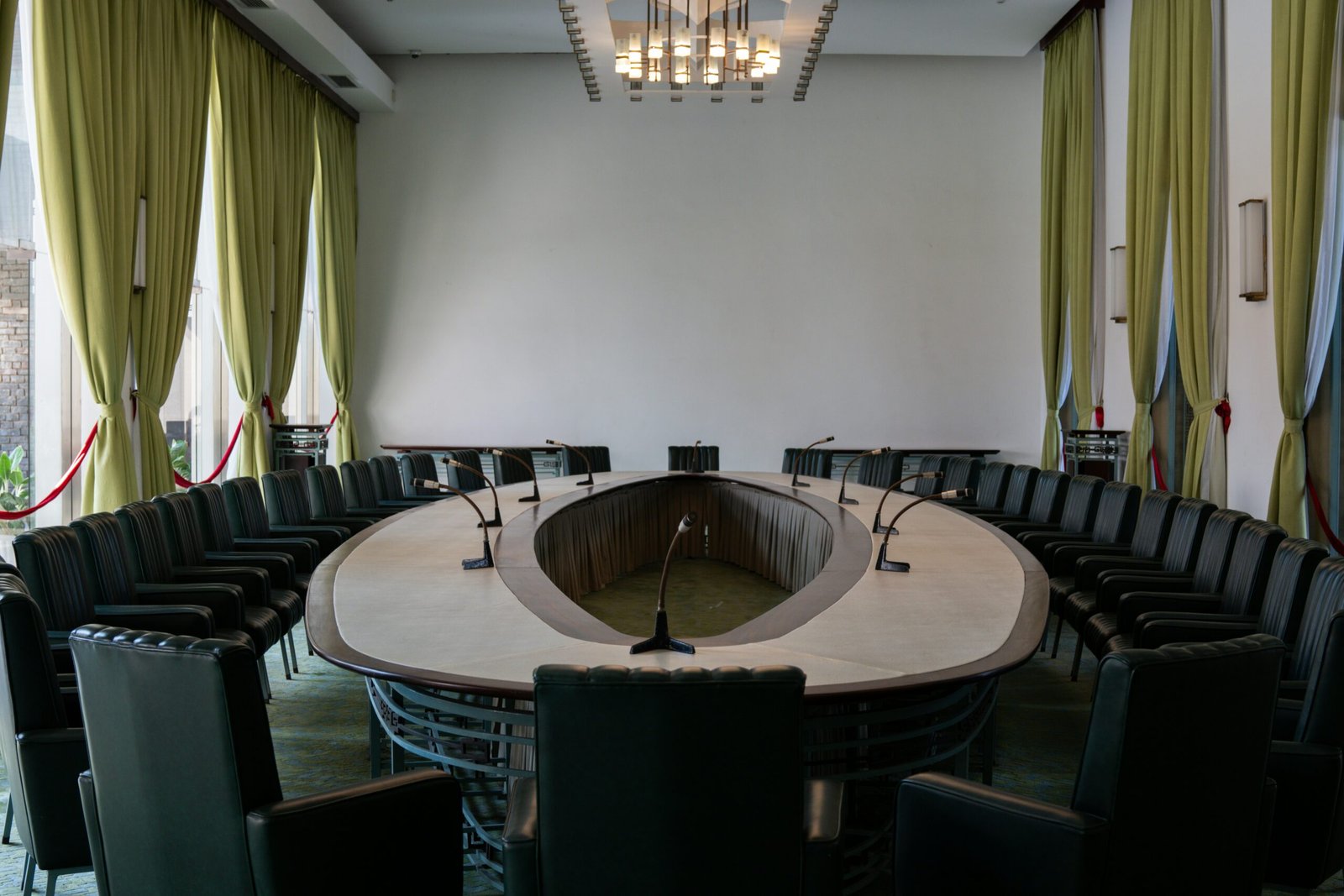 A conference room with a round table and black chairs