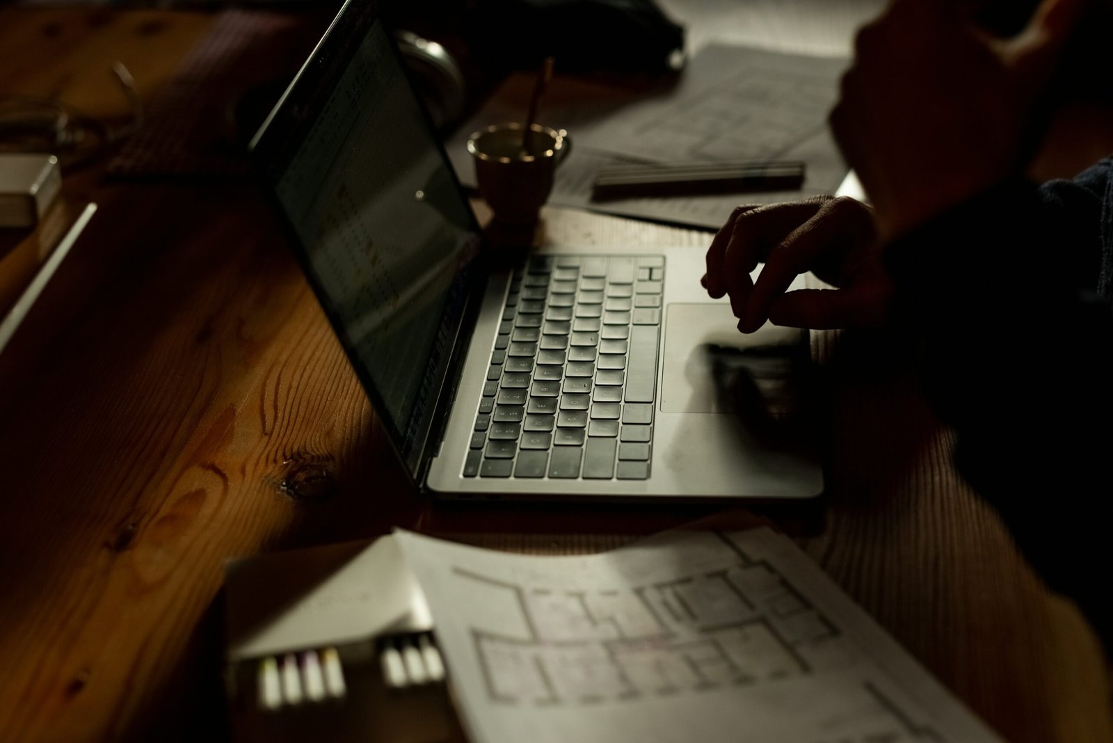 a person sitting at a table with a laptop