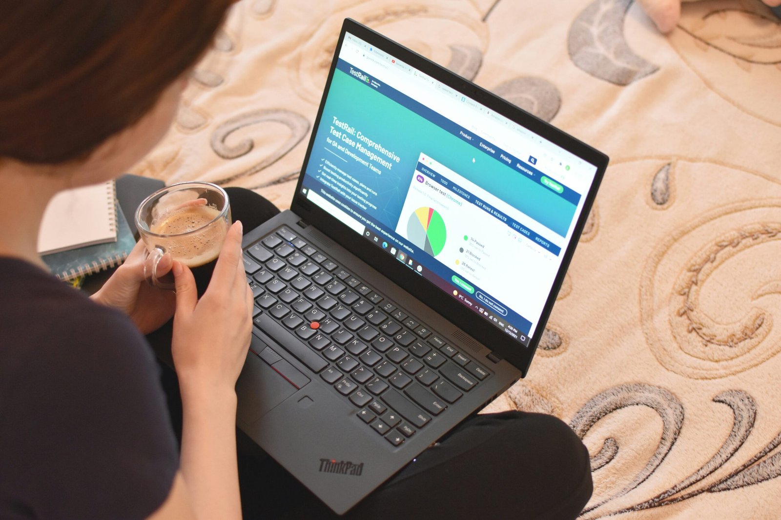 a woman sitting on a bed looking at a laptop
