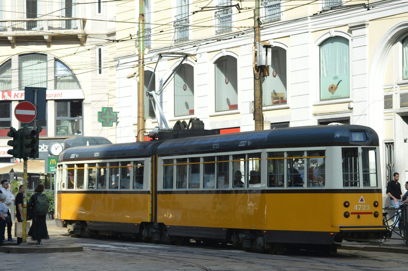 A yellow and white trolley on a city street