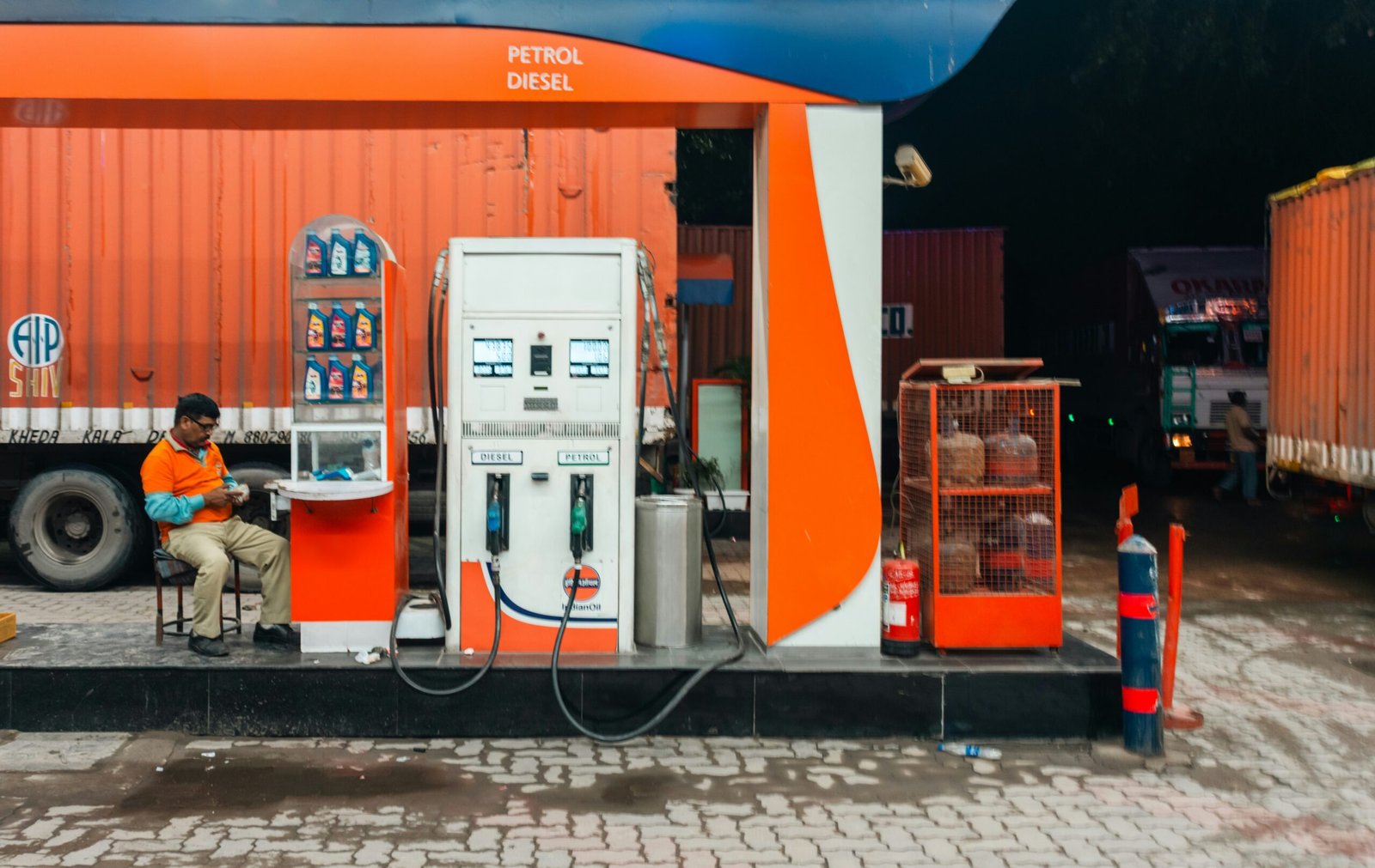 Man sitting at a petrol station at night