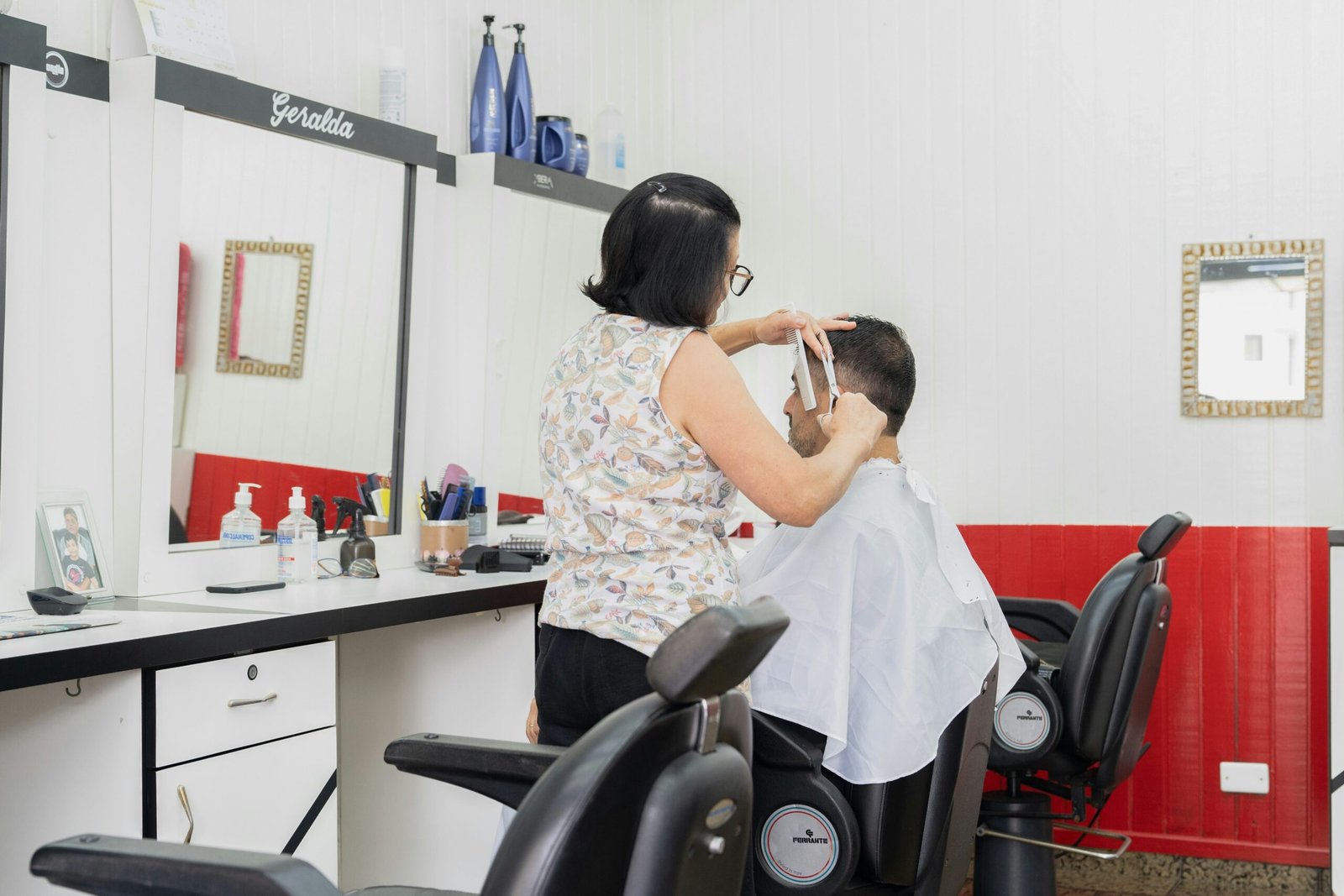 a woman cutting a man's hair in a salon