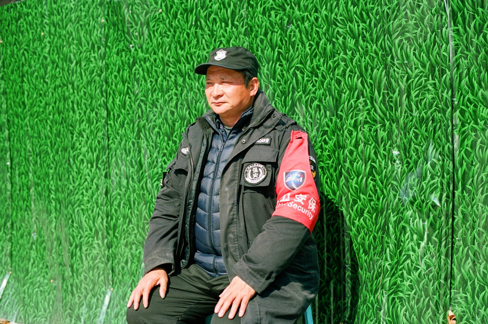 Security guard sits outside.