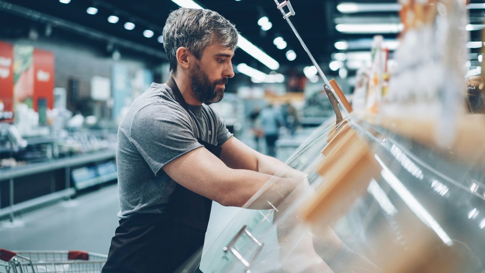 Man is bagging food items at a grocery store.
