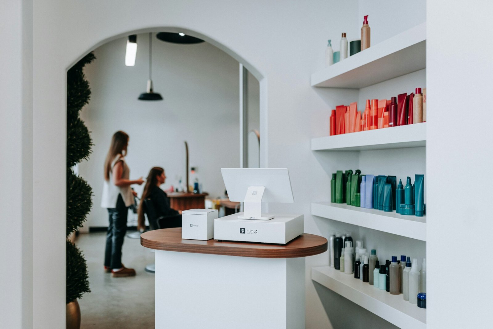 A hair salon interior with hair products and clients.