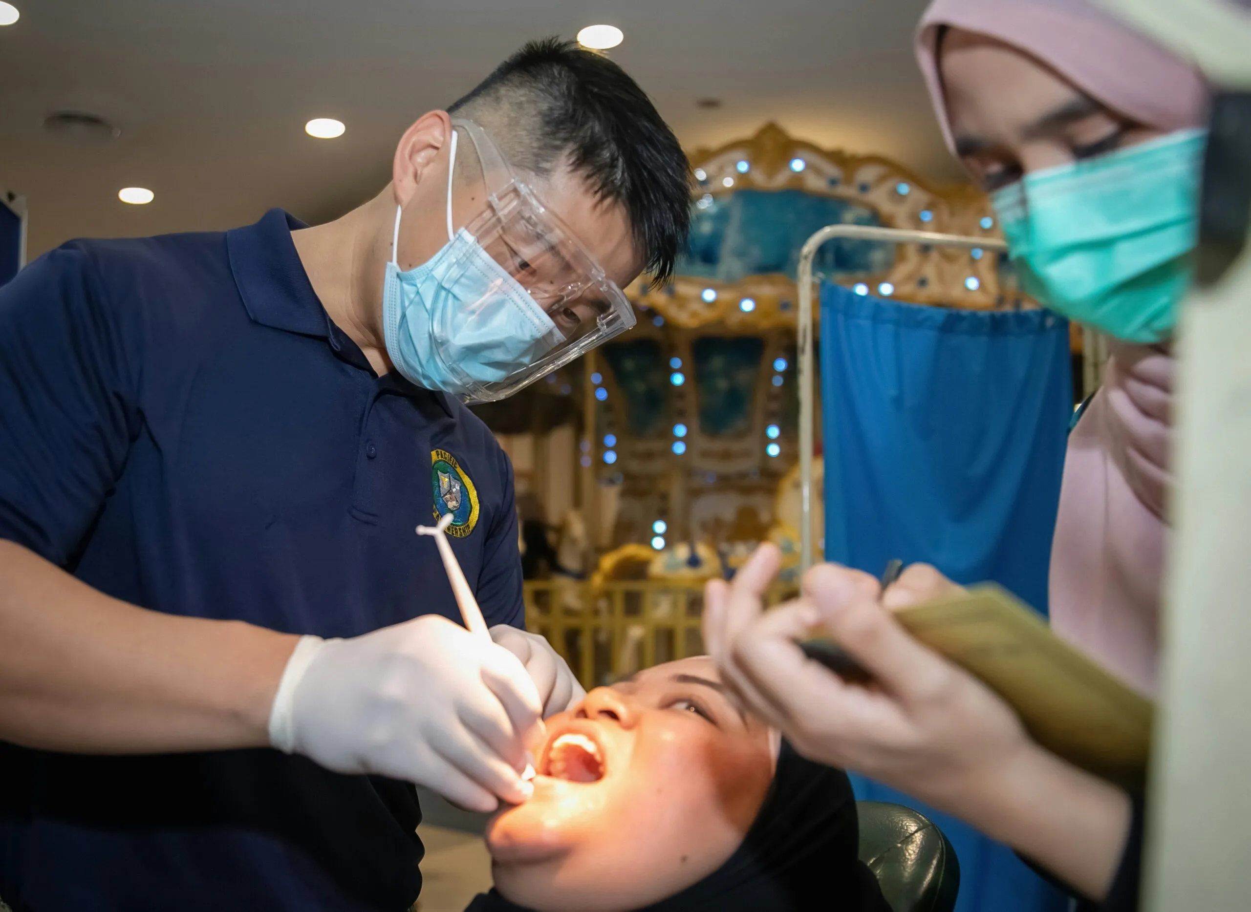 KUANTAN, Malaysia (Sept. 10, 2023) - Lt. Cmdr. Wilson Jing, Pacific Partnership 2023 dental team, conducts a dental exam at a community health fair at Kuantan City Mall during Pacific Partnership 2023, Sept. 10. Now in its 18th year, Pacific Partnership is the largest annual multinational humanitarian assistance and disaster relief preparedness mission conducted in the Indo-Pacific. (U.S. Navy photo by Mass Communication Specialist 1st Class Kegan Kay)