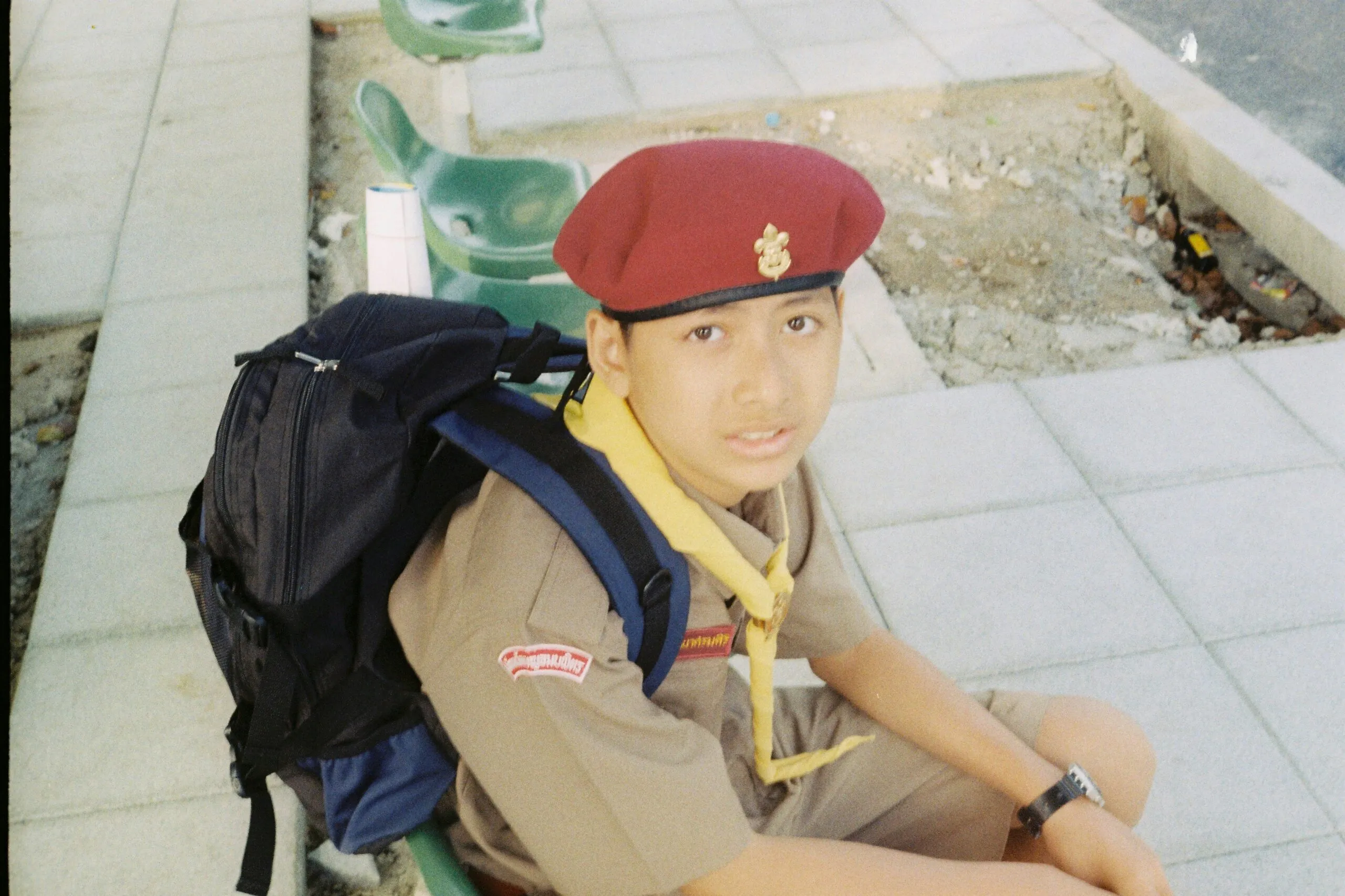 boy in red cap and brown polo shirt