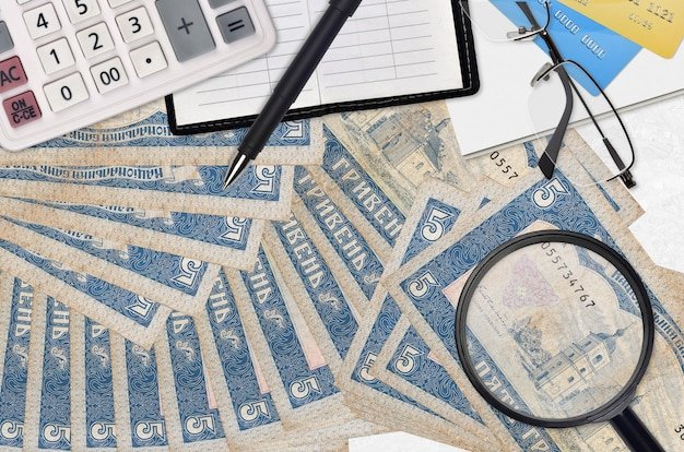 5 Ukrainian hryvnias bills and calculator with glasses and pen