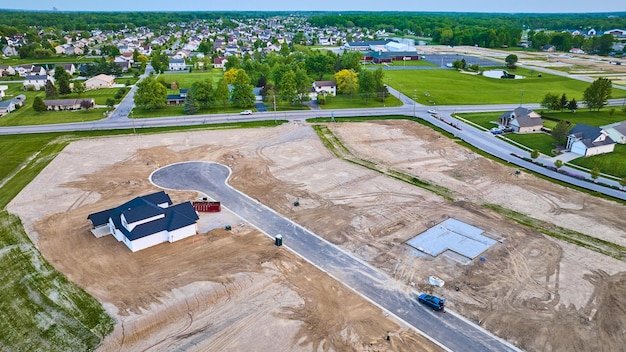 Aerial housing construction site new neighborhood cement slab one completed house distant houses
