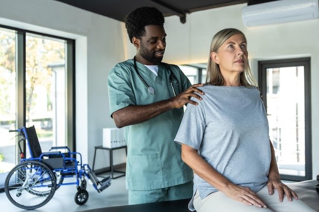 African american male doctor working on correction of female patients posture