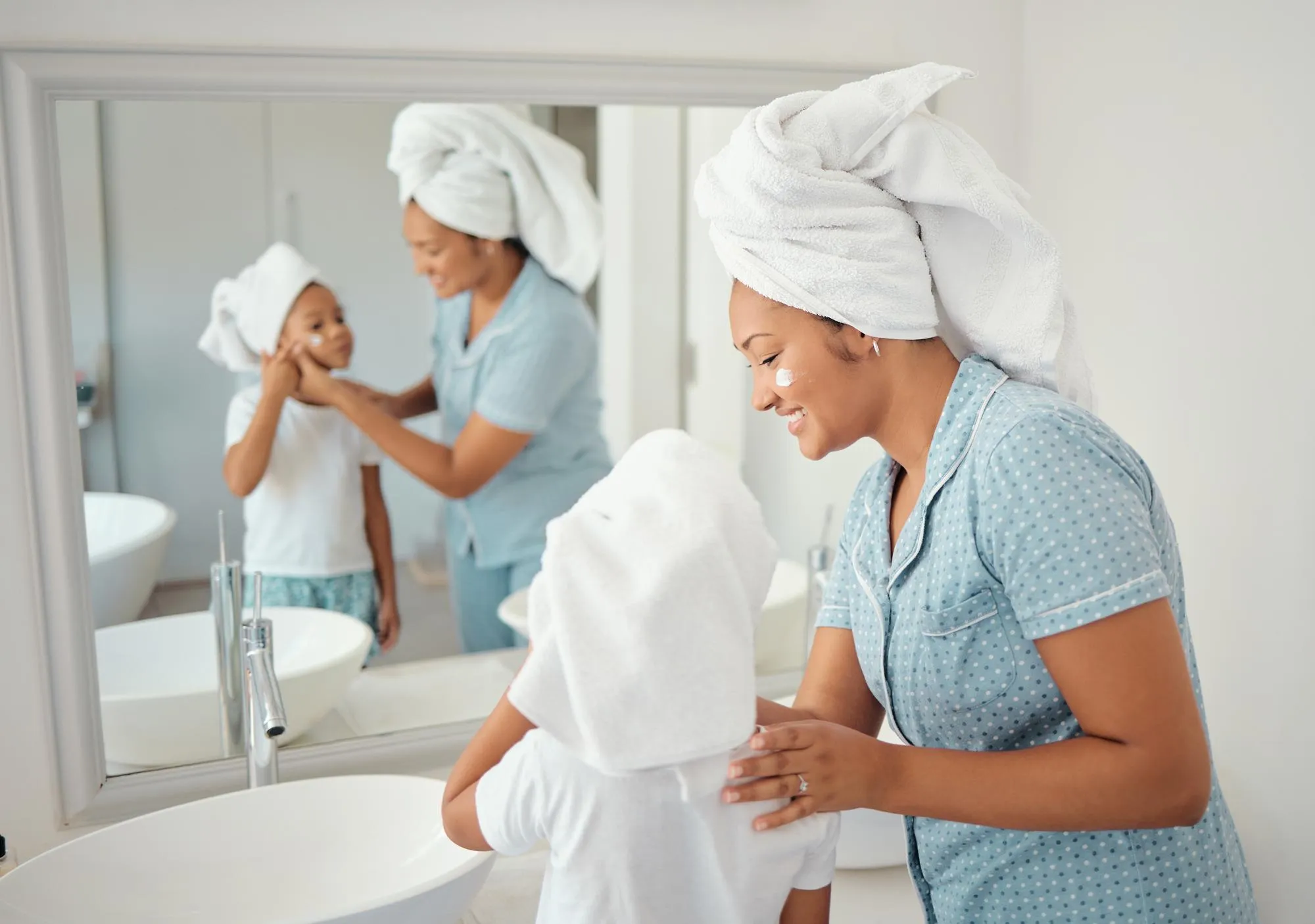 Beauty skincare and haircare by mother and daughter bonding in bathroom grooming with cosmetic treatment at home Selfcare hygiene and cleaning by parent show girl how to care for face and skin