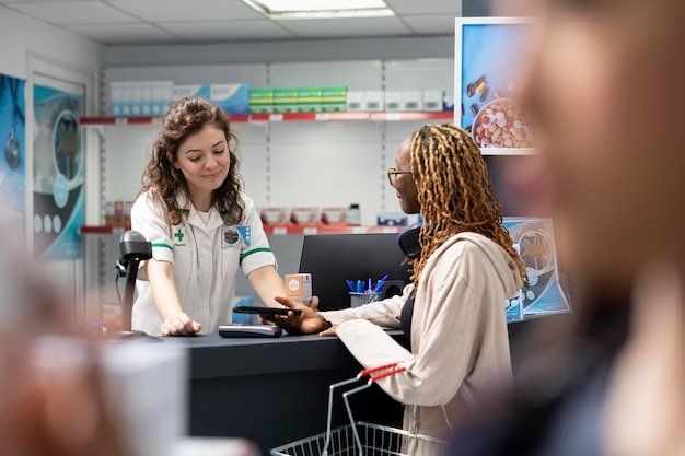 Black female client pays for prescription drugs with smartphone at the checkout