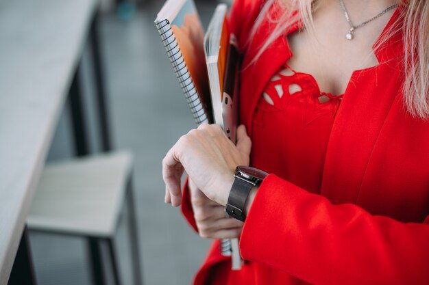 A blonde woman in red watching on her watch