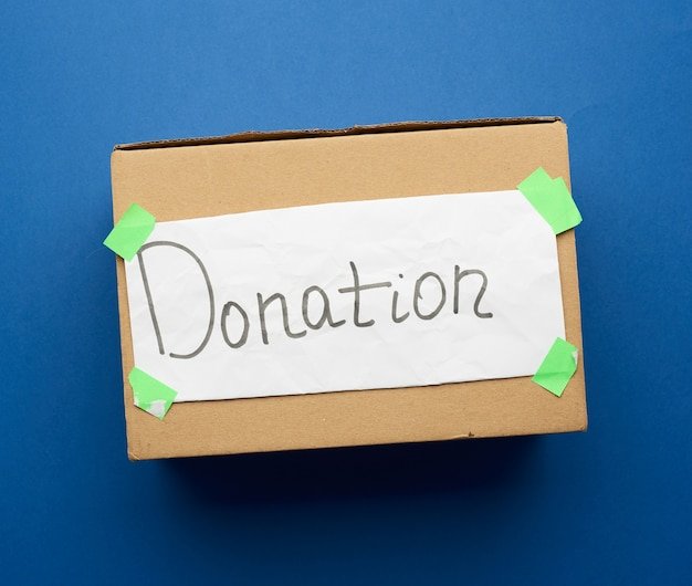 Brown cardboard box with a pasted white sheet and the inscription donations