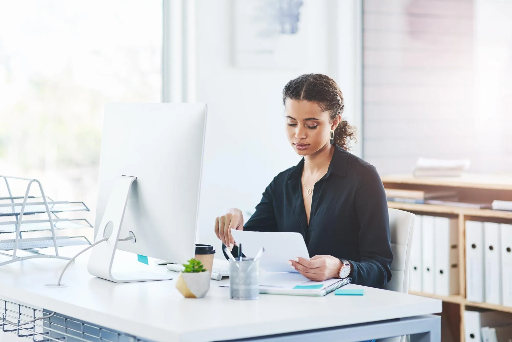 Business computer and woman with documents in office for savings budget or investment planning and research Financial review and girl auditor with company tax admin for profit check and analysis