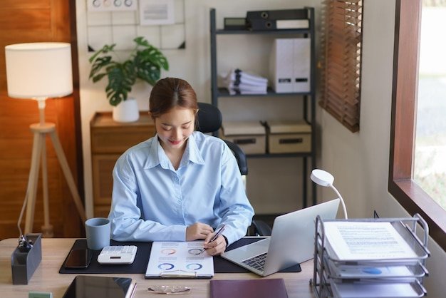 Business concept Businesswomen reading financial data and writing notes in document at workplace