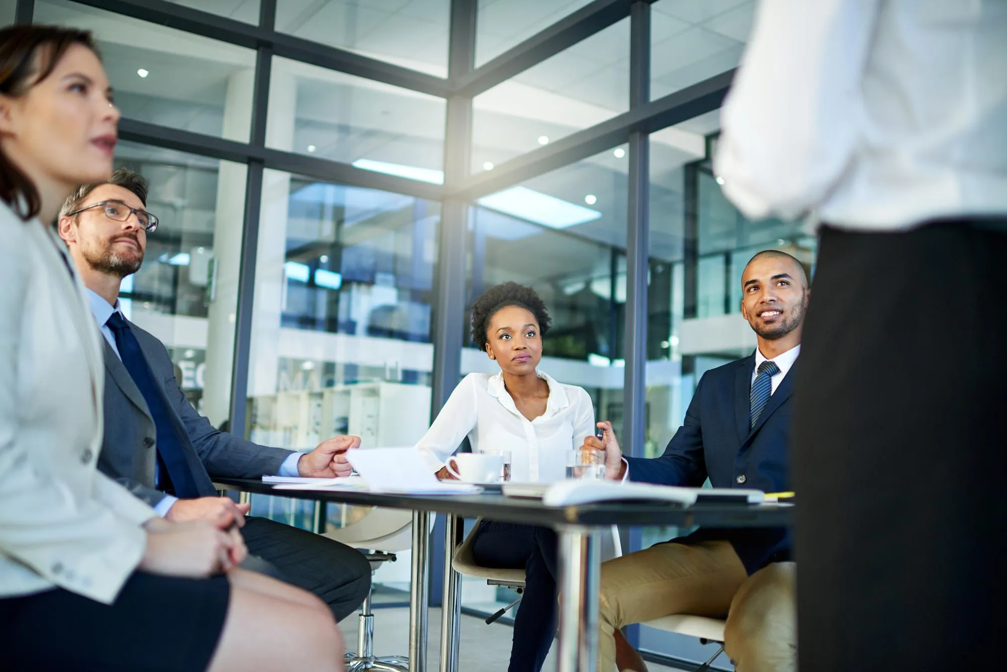 Business people meeting and discussion with team in presentation for corporate strategy or coaching at office Speaker talking to group of employees in conference for company profit stock or budget