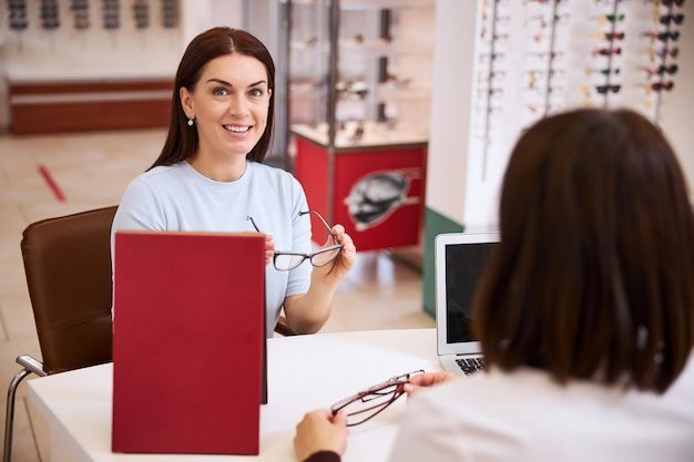 Cheerful woman finding a nice pair of glasses