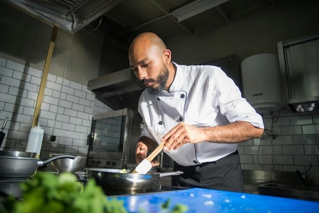 a chef in a kitchen cooking with a pot of parsley
