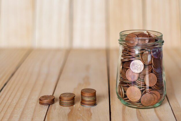 Close-up of coins in jar and on table