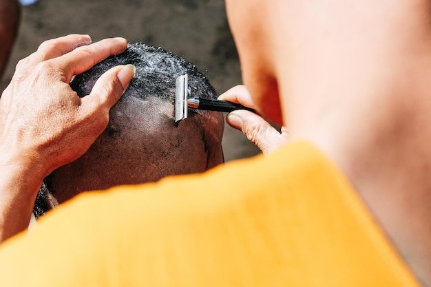 Close-up of man shaving head of boy
