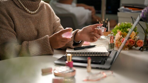 Closeup A gorgeous woman applying her perfume on her wrist over office desk Female with perfume