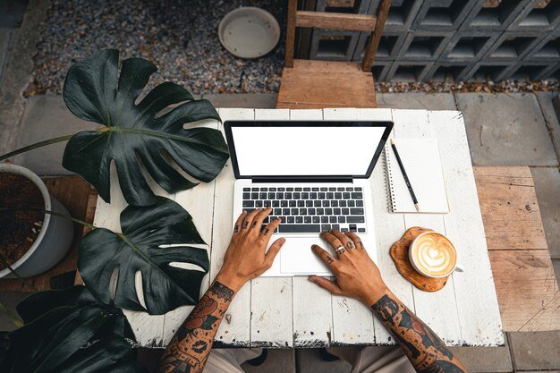 Computer and hands are working on the table with the coffee