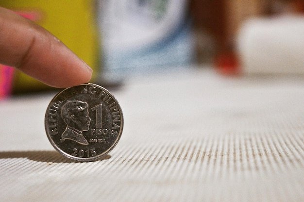 Cropped hand holding coin on table