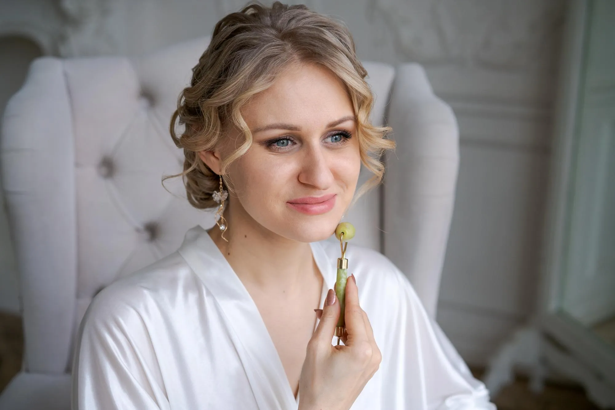 Cute caucasian woman is doing an antiwrinkle facial massage with special