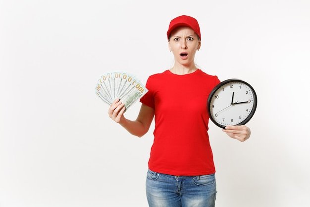 Delivery woman in red uniform isolated on white background. Shocked female in cap, t-shirt, jeans working as courier or dealer, holding bundle of dollars cash money clock. Copy space for advertisement