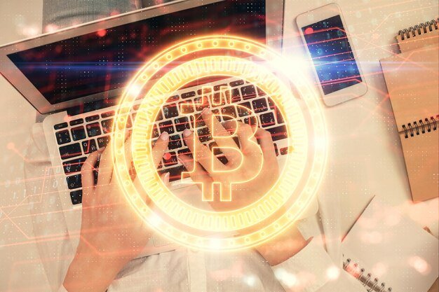 Double exposure of woman hands working on computer and blockchain theme hologram drawing Top View bitcoin cryptocurrency concept