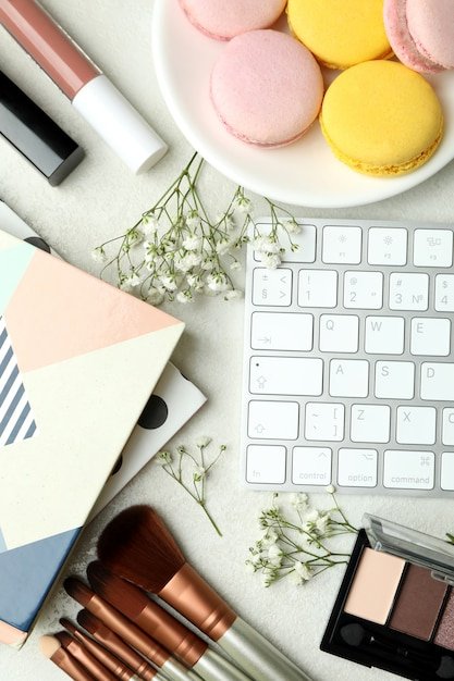 Female accessories and macaroons on white textured background