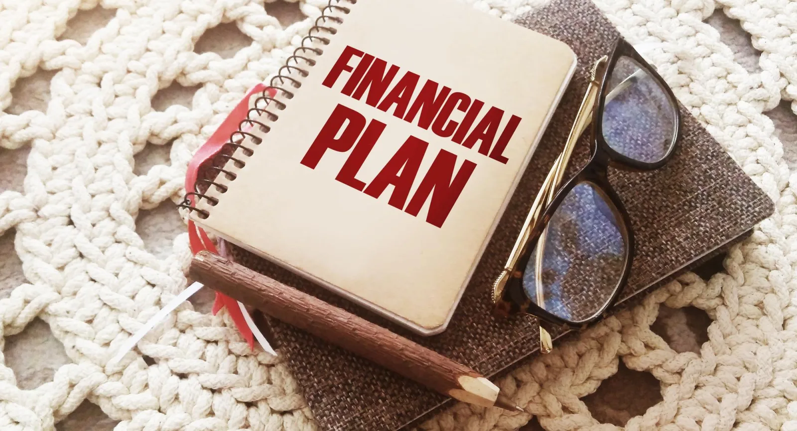 Financial Plan words on cover on notebook glasses and pen Business concept for Income Money Plan