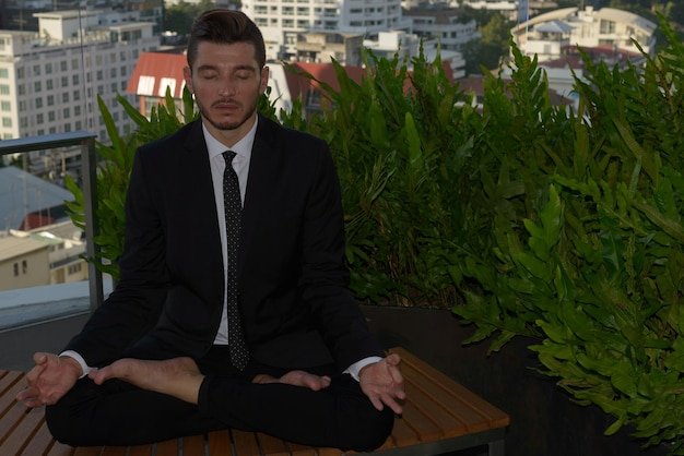 Full length of a young man sitting outdoors