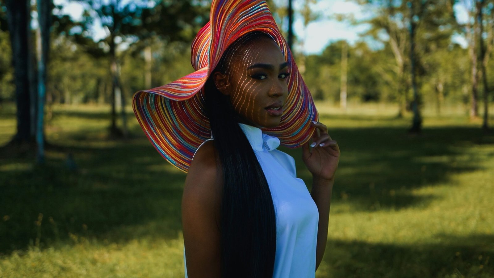 a woman wearing a colorful hat in a park