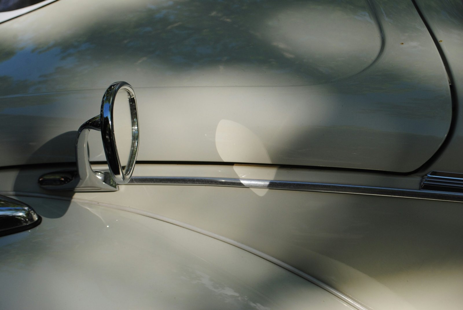 A side mirror reflects on a sleek car.