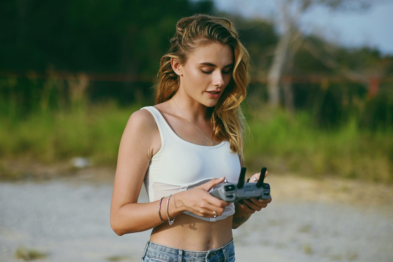A woman standing on a beach holding a camera
