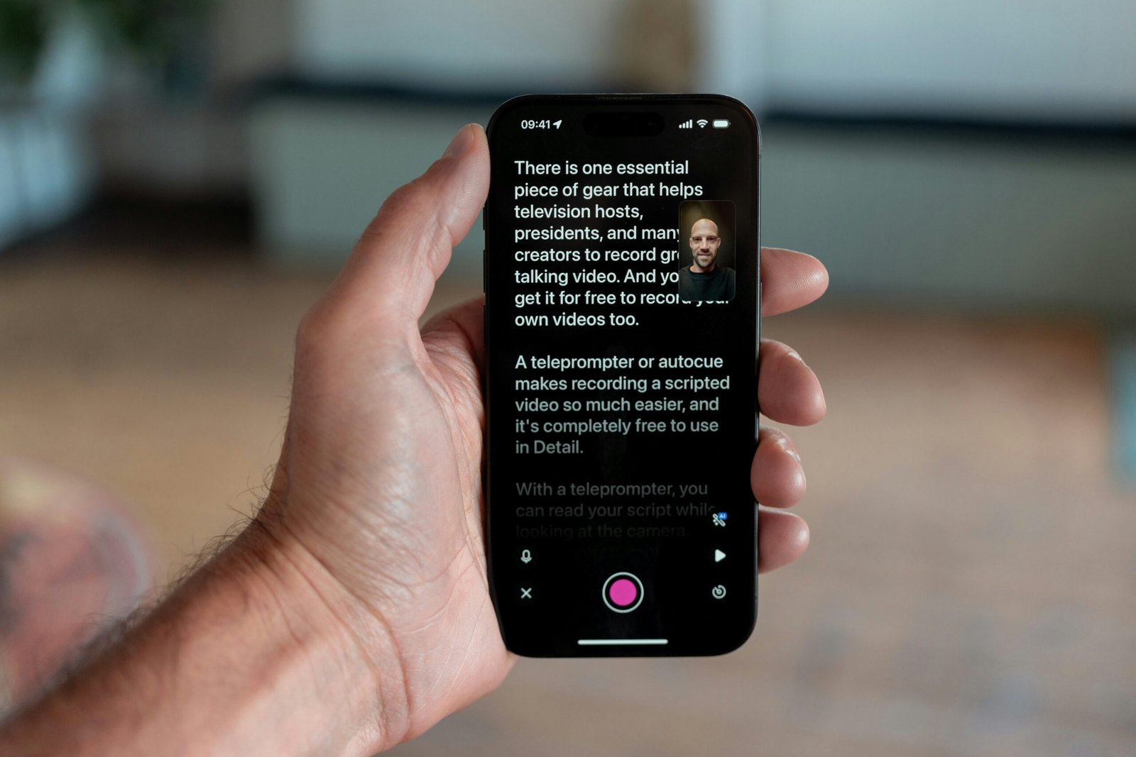 Hand holding smartphone displaying teleprompter app