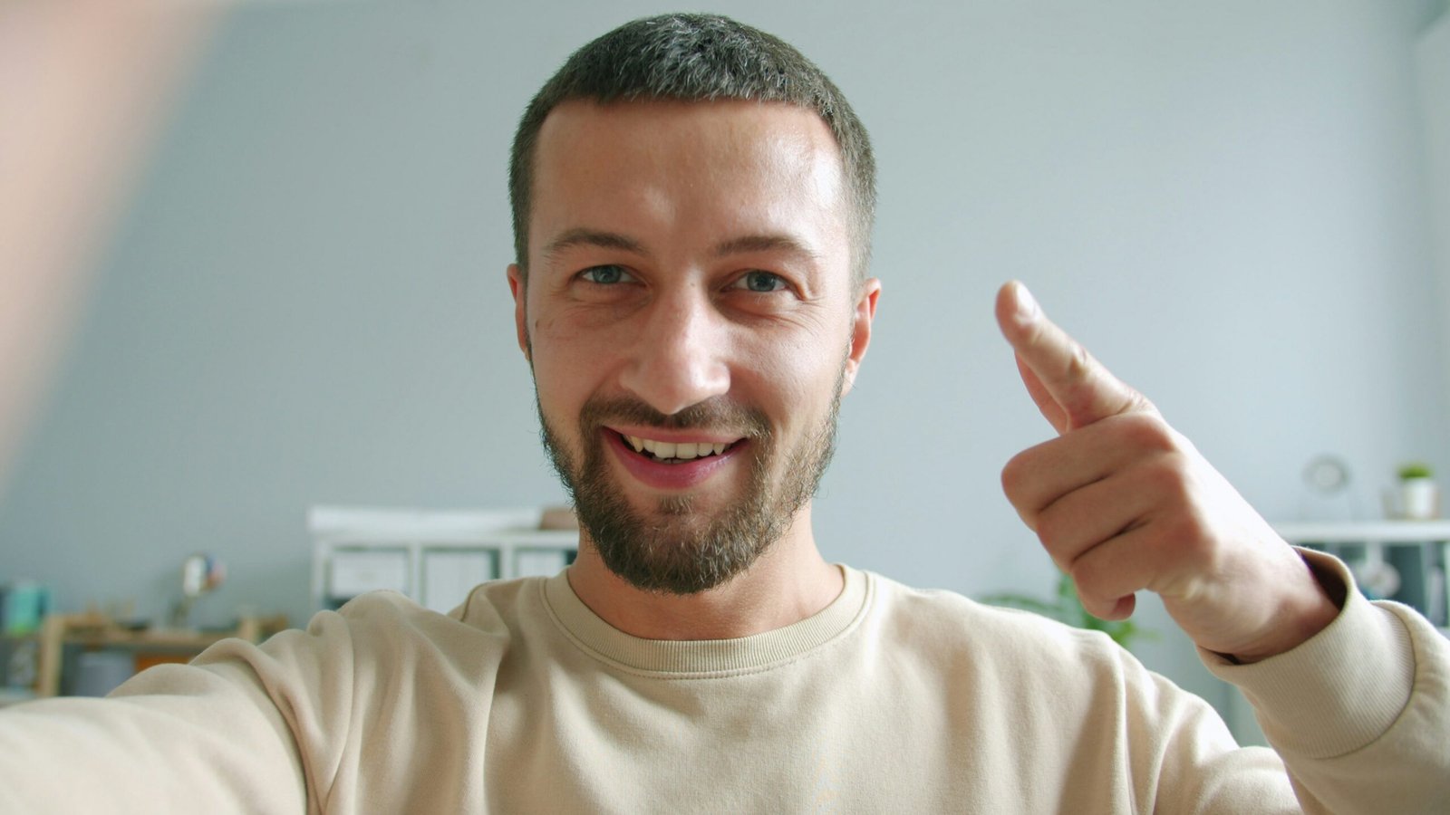 Man smiling and giving a thumbs up gesture.