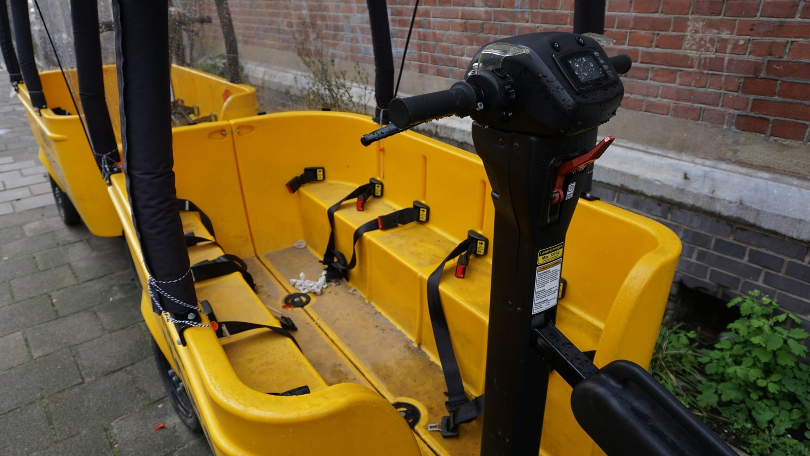 a row of yellow seats sitting next to a brick wall