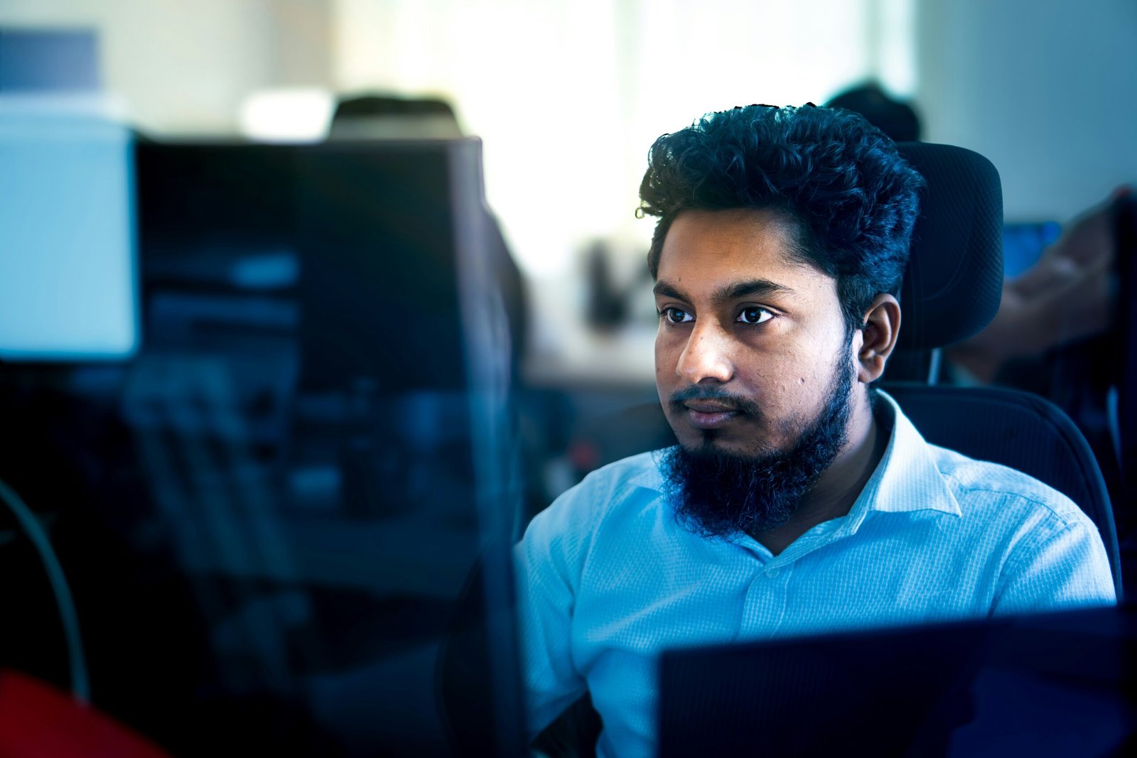 Man working on a computer in an office setting.