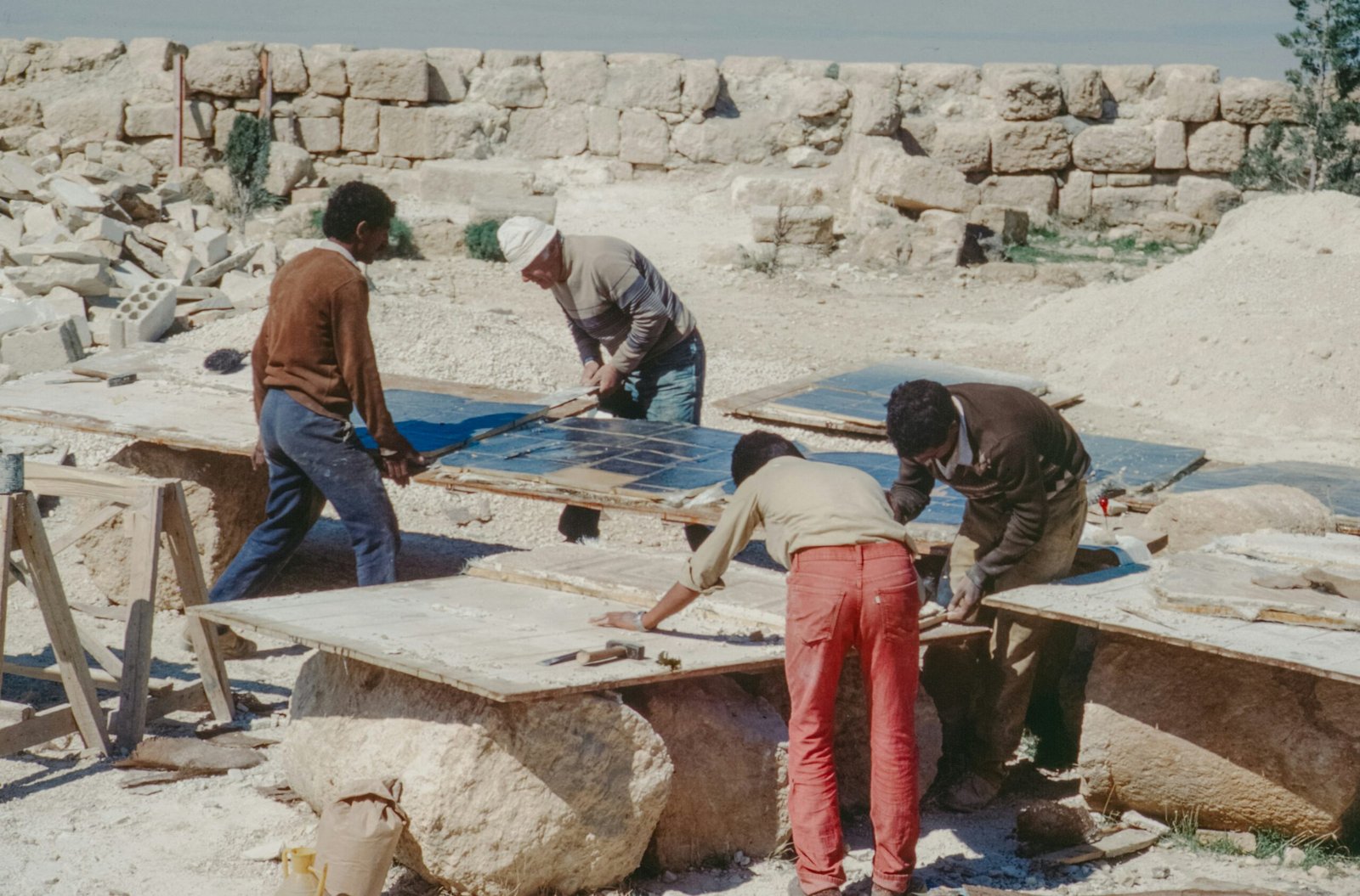 Workers polishing large stone slabs outdoors