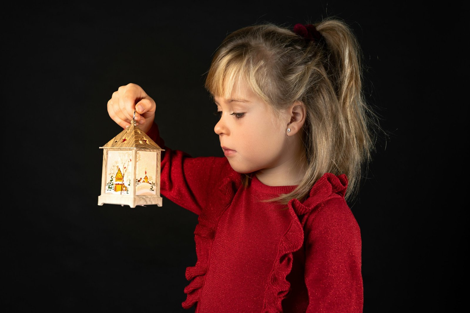 a little girl holding a small house in her hand