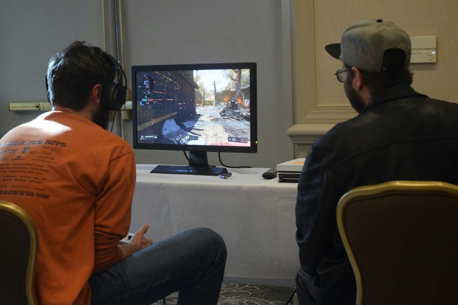 two men playing games facing monitor
