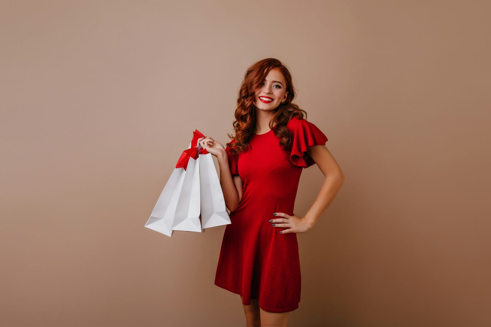 a woman in a red dress holding a white bag