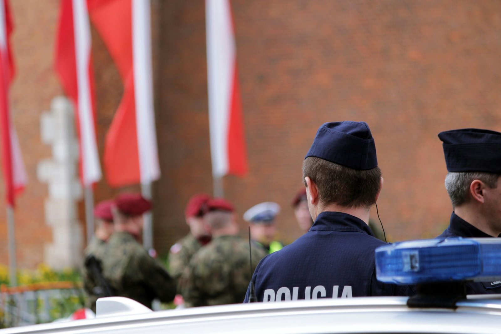 two police officers standing in front of a police car