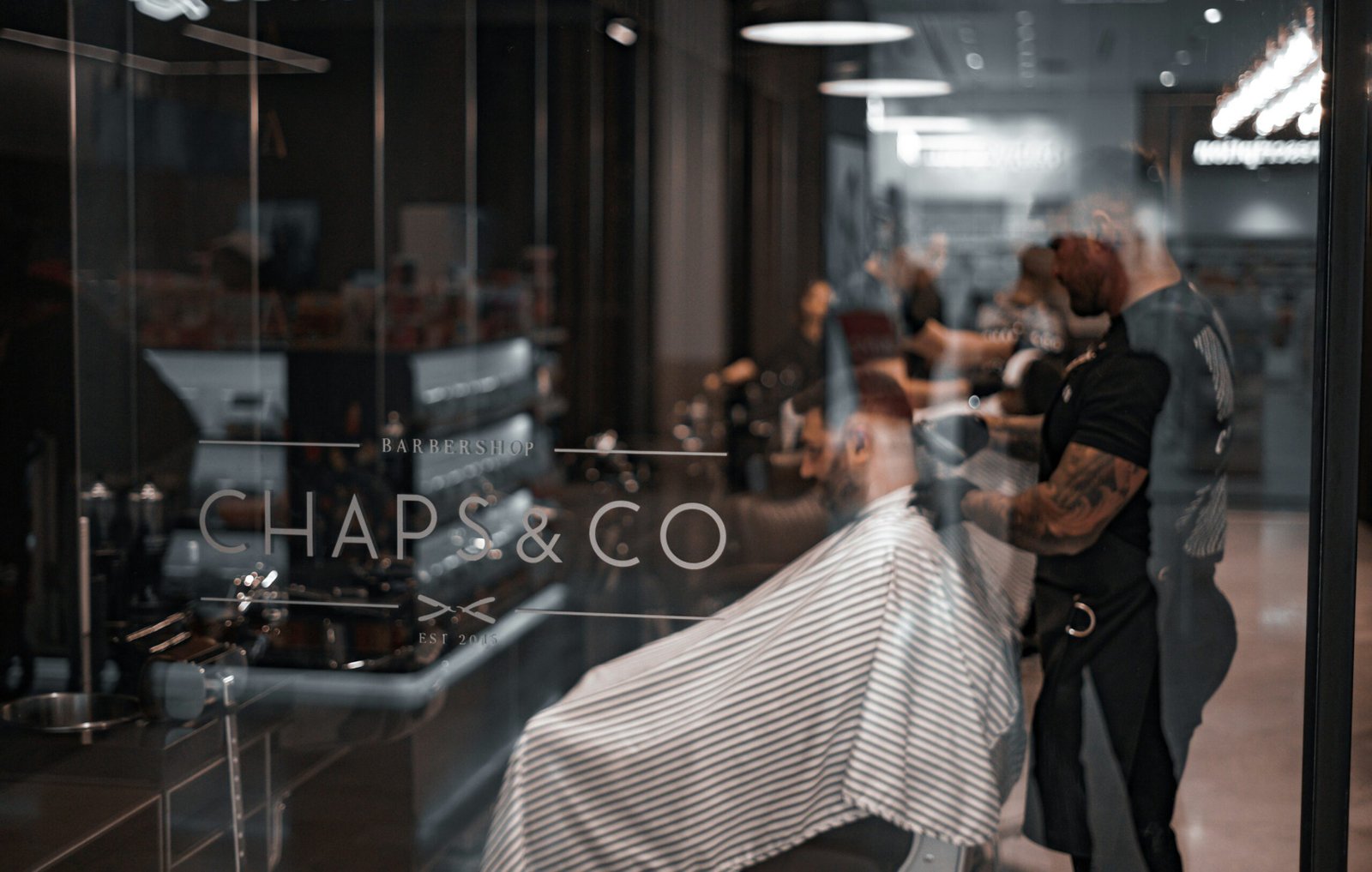 Barber shop interior with clients receiving haircuts.